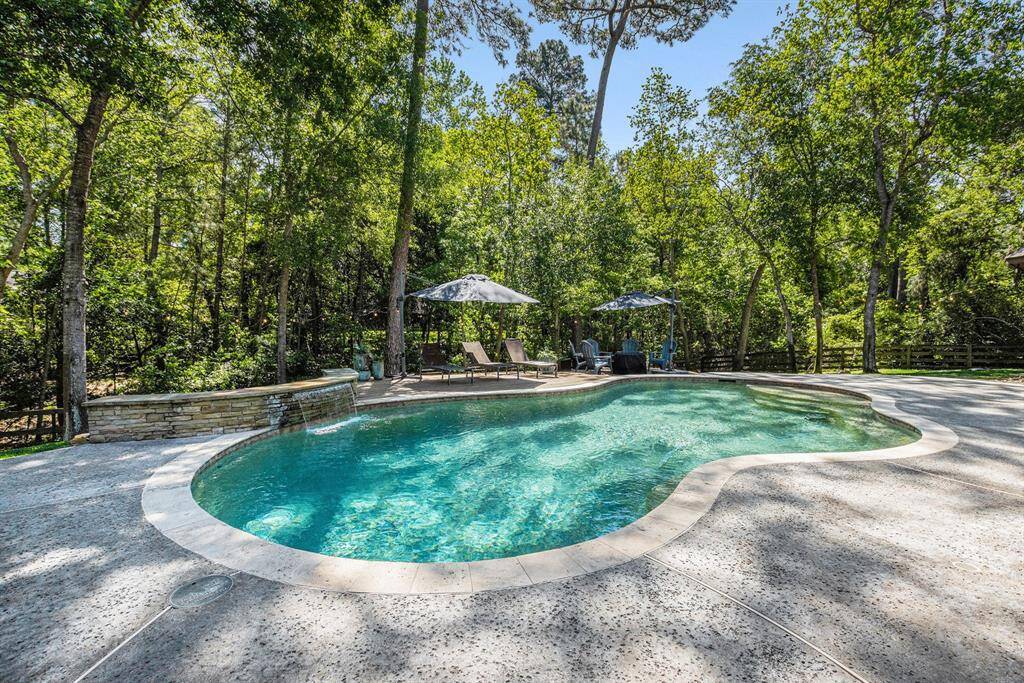 Enjoy resort-style living in your own backyard with this beautiful pool, surrounded by mature trees, a sun deck for relaxing, and plenty of space!