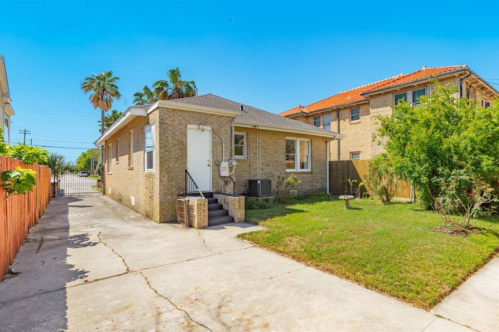 Photo showing gated driveway and fenced in back yard area. There is a small 'mud' room just inside the back door which is in view.