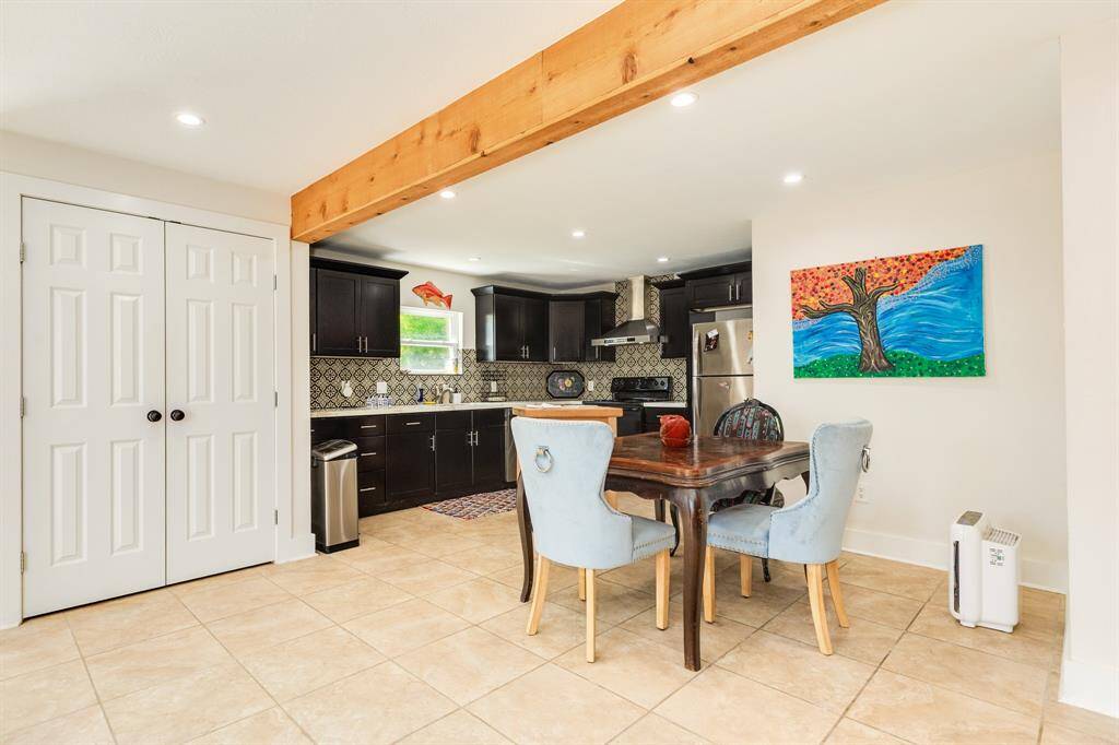 Nice sized kitchen, dining area and utility closet behind double doors in view.