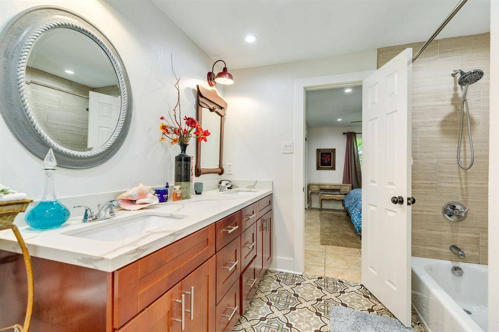 Spacious bathroom in garage apartment with tub/shower arrangement & double vanity sinks.