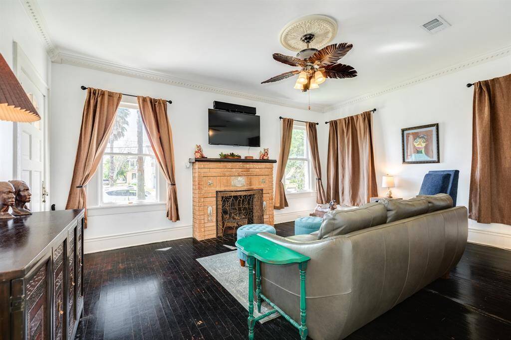 Front parlor with gas log fireplace, painted wood floors.