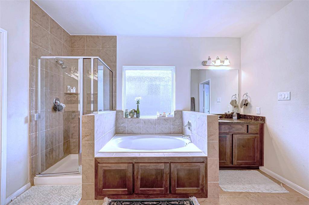 The separated shower and tub provide versatility and convenience, while the second sink cabinet here with lots of storage space offers functionality without compromising on style.