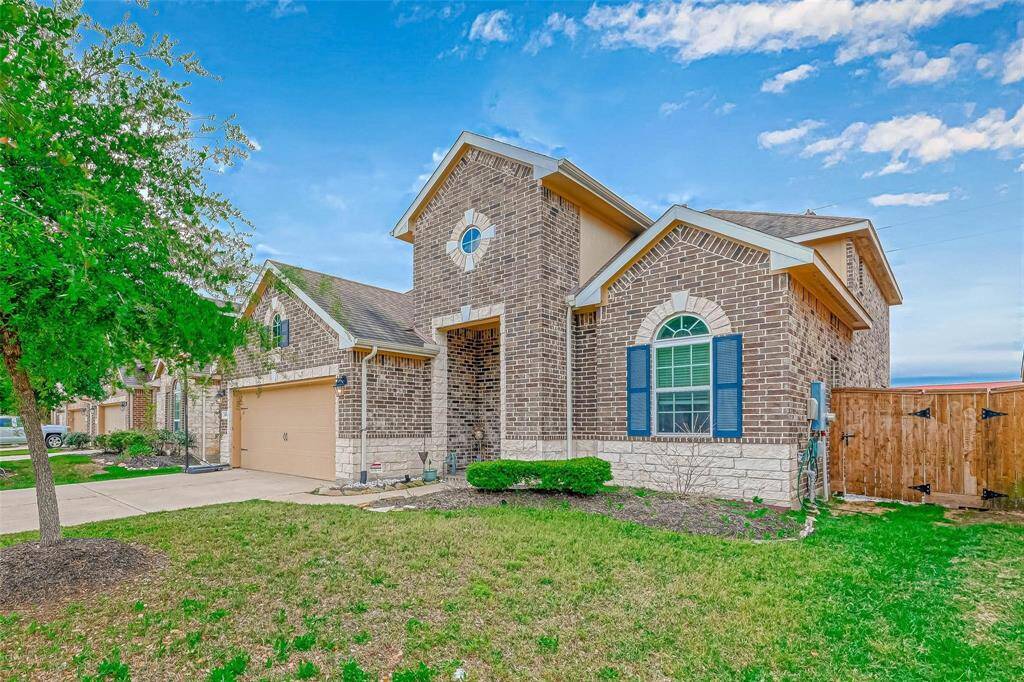 This home has beautiful curb appeal including classic brick elevation, manicured landscape, and a green front lawn with maturing trees.