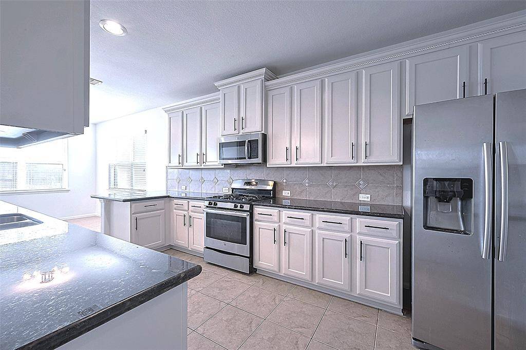 The large cabinets and crown molding have been recently painted to give the kitchen a fresh look.