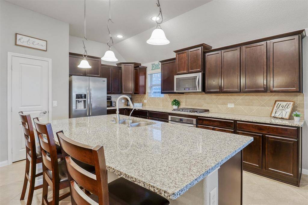 Enjoy stainless steel appliances, a gas cooktop, built-in microwave, and a neutral backsplash that ties it all together with warmth and functionality.