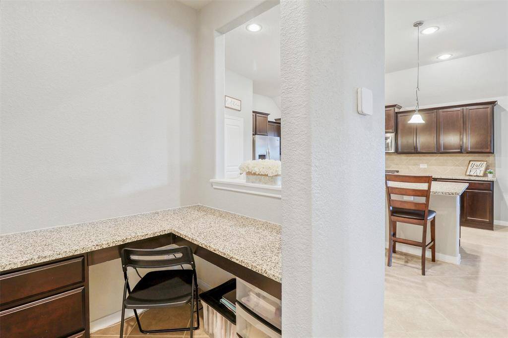 The dedicated laundry room includes a full-size washer and dryer setup, overhead shelf for storage, and room for a deep freezer—adding everyday functionality to this thoughtfully designed home.