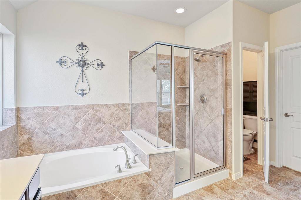 A pair of separate walk-in closets offers plenty of space for multiple large wardrobes, complete with convenient access just steps from the vanity and shower areas—perfect for staying organized.