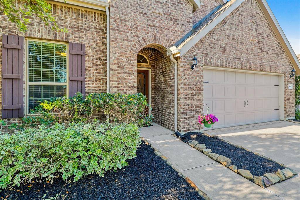 A closer look at the front entrance showcases thoughtful landscaping, a covered entryway, and beautiful brickwork that speaks to the quality craftsmanship of Pulte Homes.
