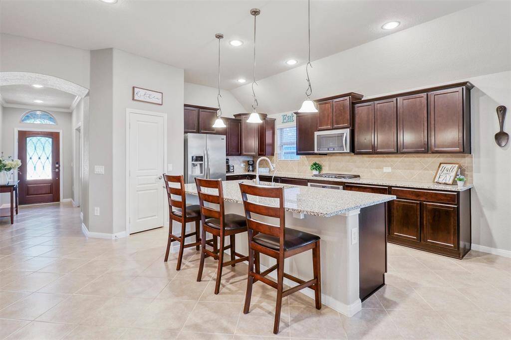 Granite countertops continue along the entire kitchen perimeter, offering tons of prep space and storage—truly a culinary space designed for both form and function.