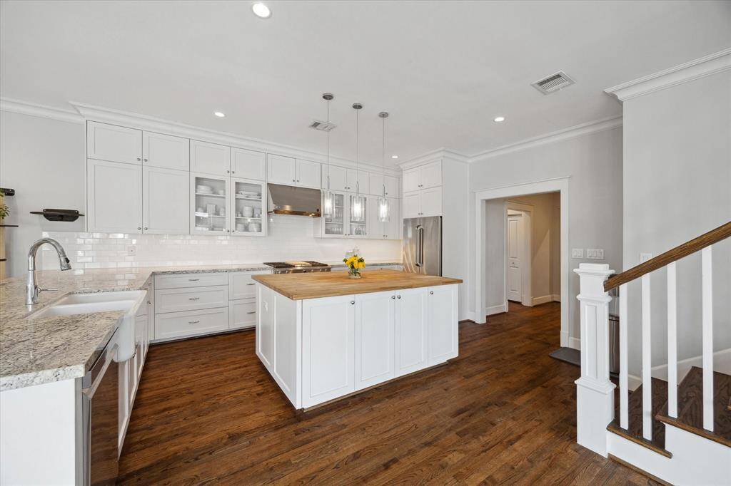 A chef’s dream layout with ample storage, sleek stainless steel appliances, and glass-front cabinets that add a touch of elegance to this highly functional space.