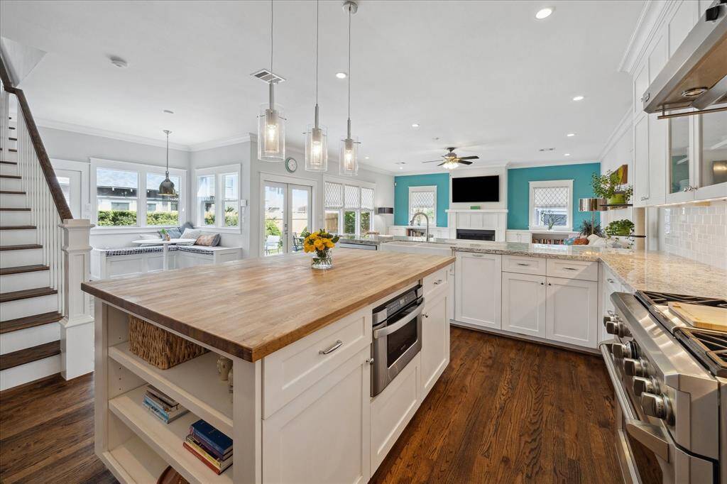 Enjoy open-concept living at its finest with a kitchen that flows seamlessly into the family room and breakfast nook, all bathed in natural light from walls of windows.