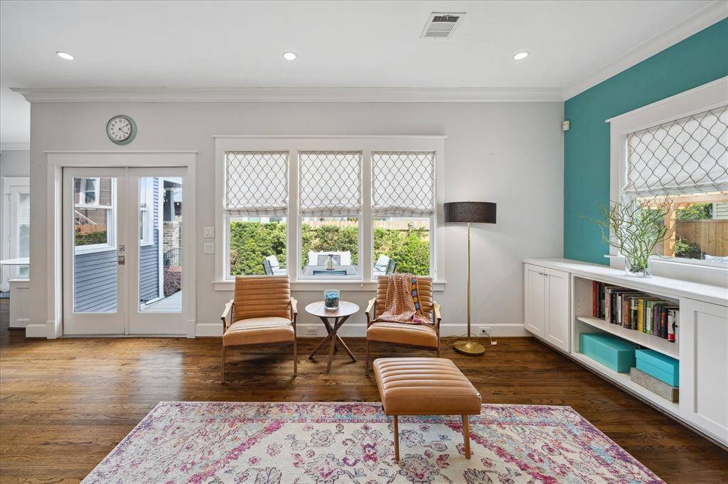 A sunny seating nook in the living room offers the perfect spot to curl up with a book or enjoy views of the landscaped backyard through charming grid-paneled windows.