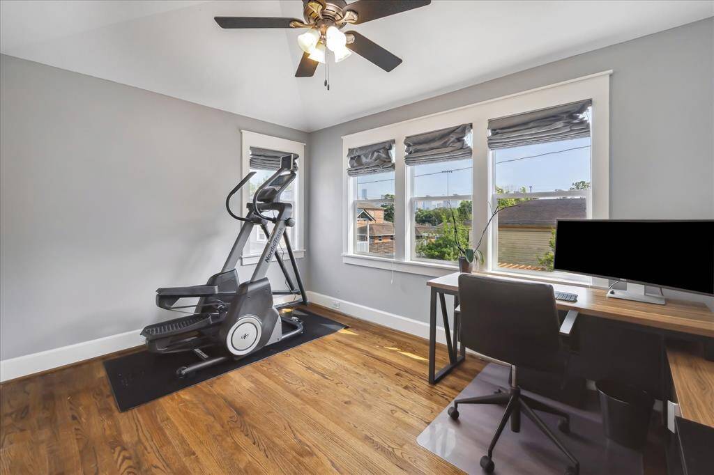 This flexible second-floor space is ideal for a home office, workout room, or creative studio — complete with hardwood floors, crown molding, and large windows that frame views of the city skyline.