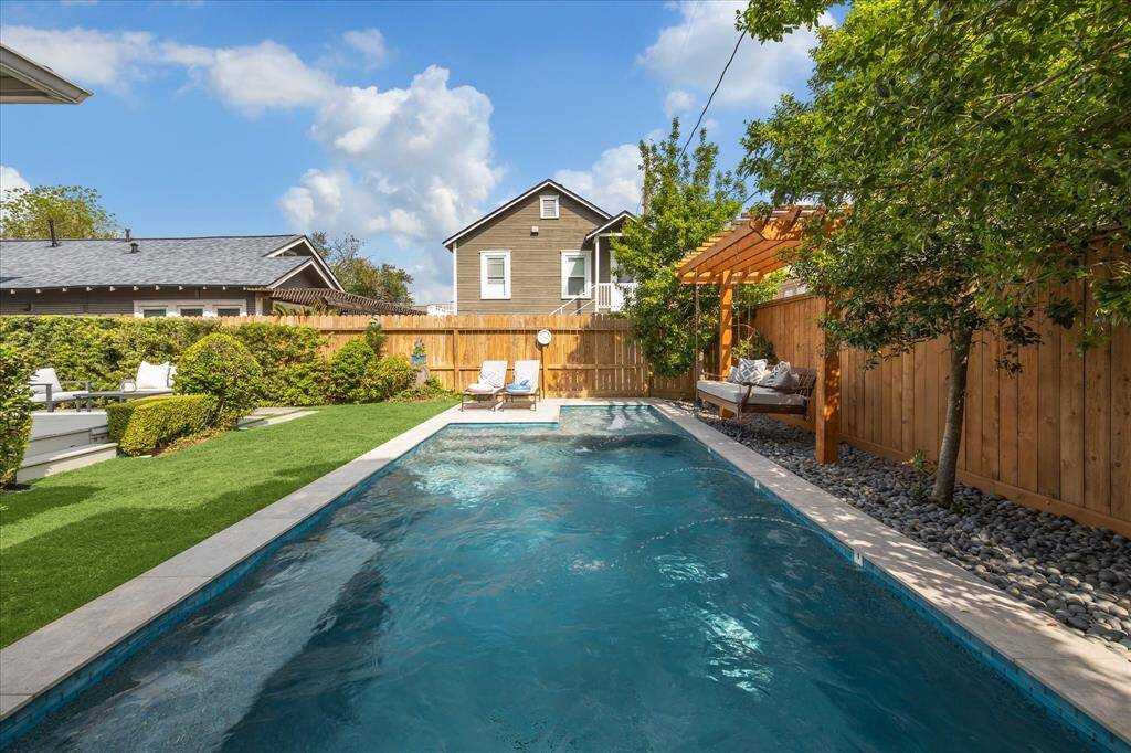 Enjoy peaceful afternoons by the pool under the pergola, complete with lounge chairs and privacy landscaping. The perfect balance of shade and serenity.Framed by mature trees and a wooden privacy fence, this inviting pool is the centerpiece of a beautifully manicured yard designed for both fun and tranquility.