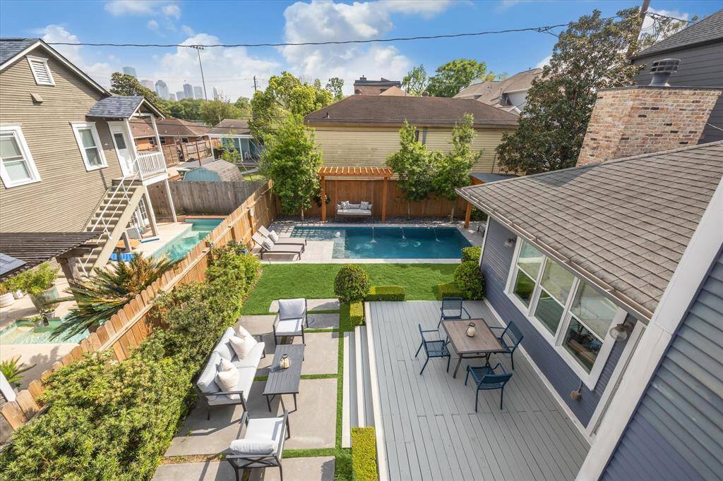 oak in this stunning view from the second-floor balcony—lush landscaping, a sparkling pool with water features, and multiple outdoor living spaces designed for both relaxation and entertaining. Imagine coming home to this every day—come tour and experience it for yourself!