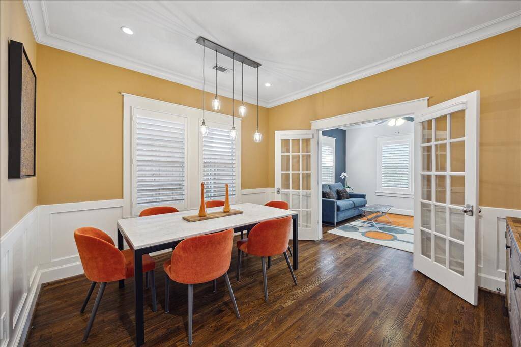 French doors open to the front living area, adding flow and function to the dining space while maintaining charm and character with bold accent colors and elegant trim details.