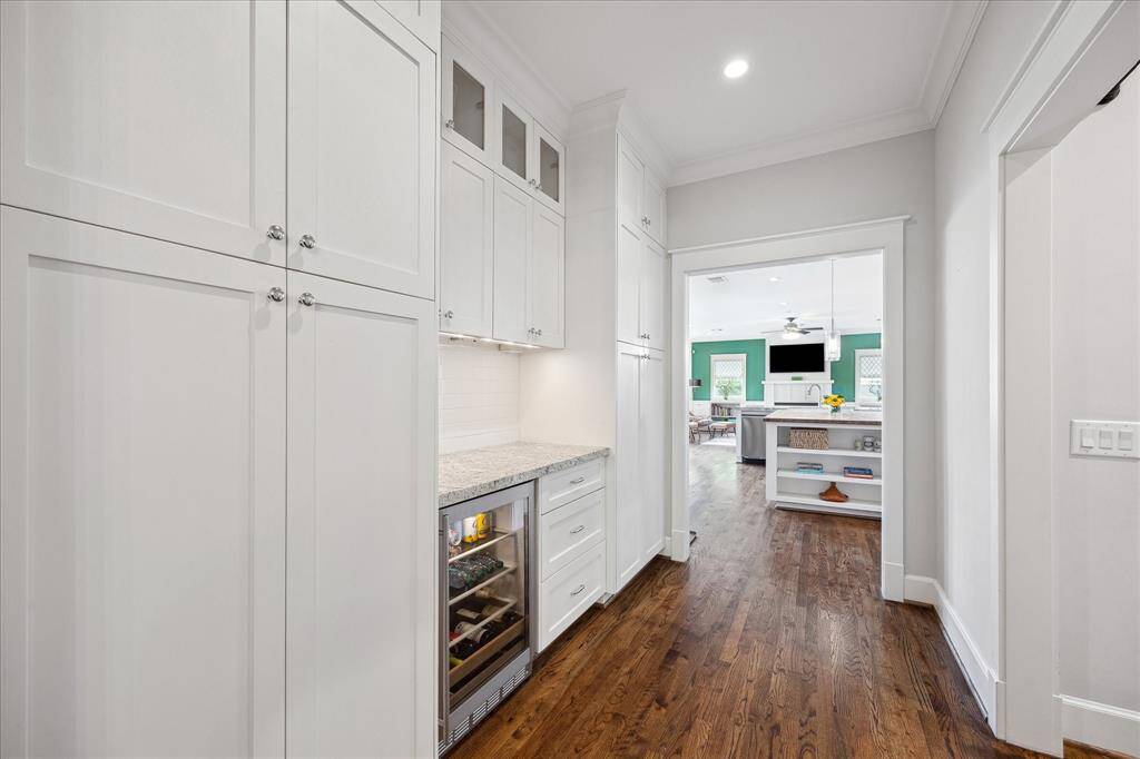This thoughtfully designed butler’s pantry offers additional storage, granite countertop prep space, and a built-in beverage fridge — the perfect link between the formal dining room and the open-concept kitchen.