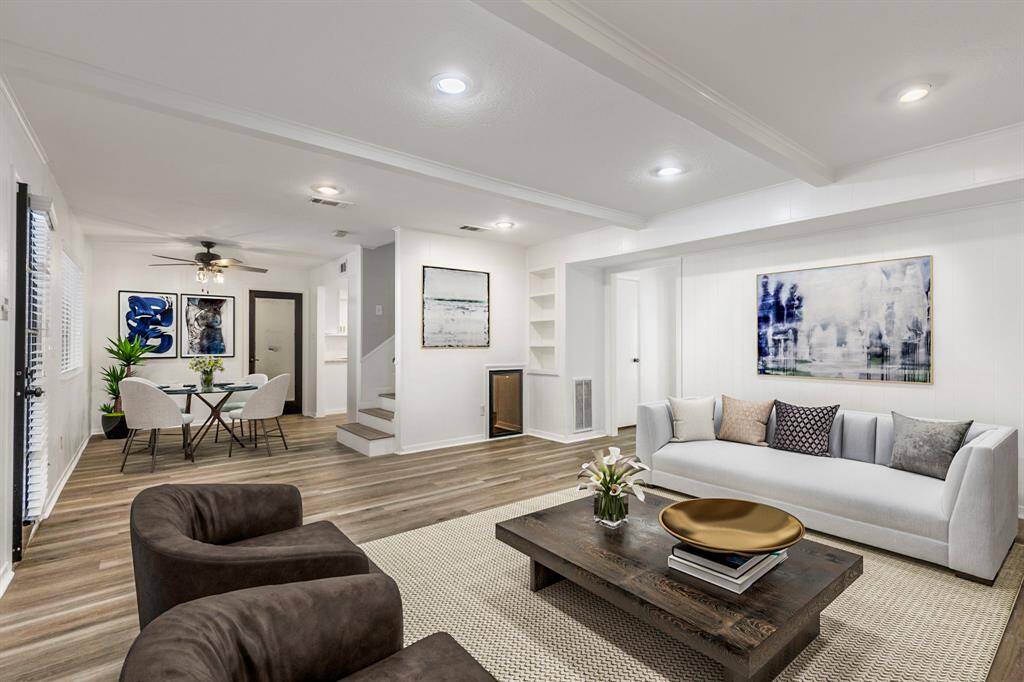The living room is oversized and features recessed lighting, custom built-ins, beautiful beams, a cozy fireplace and a built-in wine fridge.