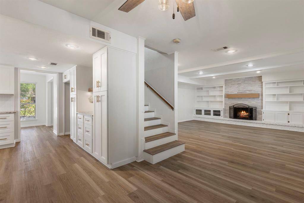 The stairs are. tucked away between the kitchen and living room. It helps the layout maintain an open concept while still providing some sectioning to the home.