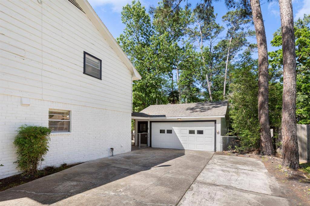 The 2-car garage at the end of the lengthy driveway is attached by a breezeway to the home. Behind it is the flex room and additional storage.