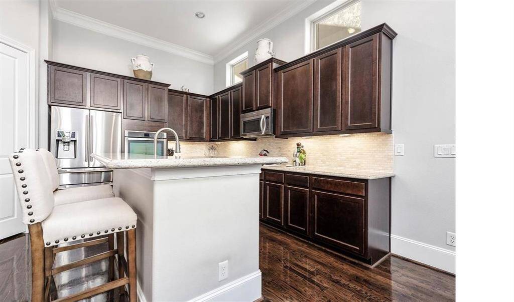 This expansive kitchen also offers a cozy barstool area, ideal for enjoying a midnight snack or savory a relaxed morning breakfast.