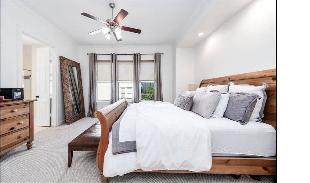 This elegant primary bedroom located on the second floor features soaring high ceilings, expansive windows that fill the room with natural light.