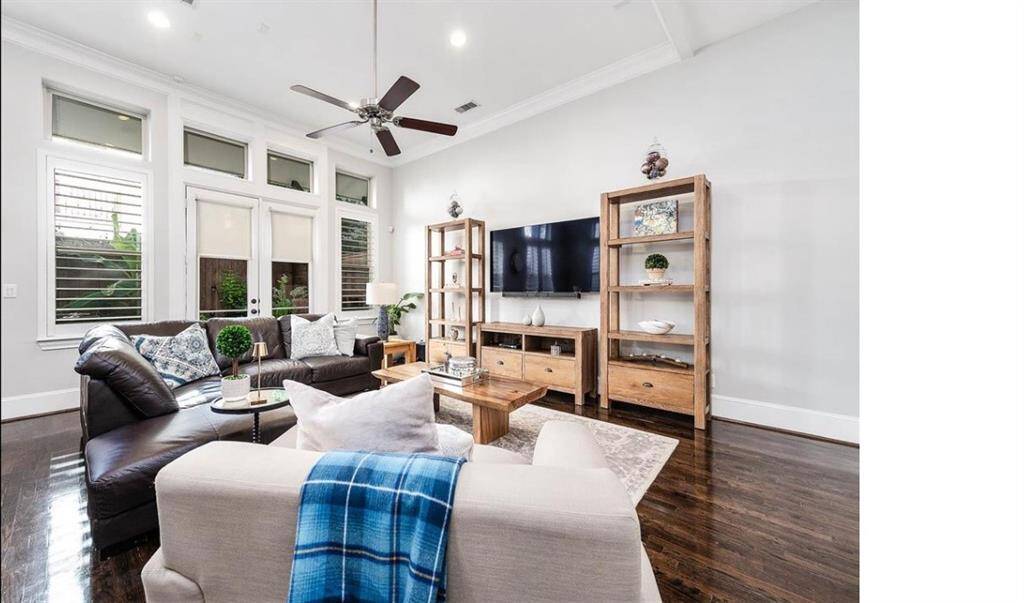 Spacious living room with soaring ceilings and walls of windows that flood the space with natural light, creating a grand and welcoming atmosphere.
