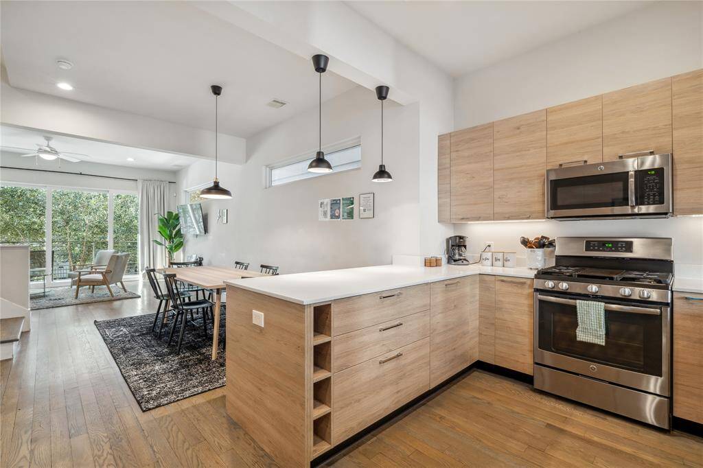 This modern chef’s kitchen is designed with both style and function in mind, featuring an attached island that seamlessly extends from the wall, creating an efficient and space-saving layout.