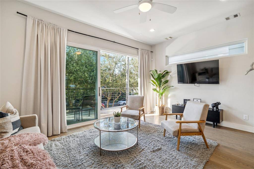 Step into a bright and spacious living area, featuring high ceilings, recessed lighting, and large windows that flood the space with natural light.
