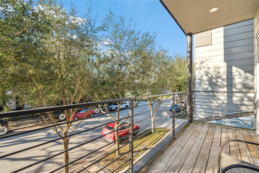 This elevated space features a sleek black metal railing, providing an open yet secure feel while complementing the home’s modern design.