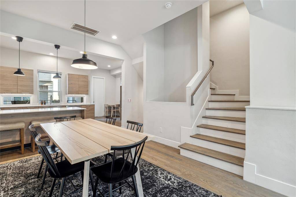 The dining area is perfectly positioned near the stairway leading to the third floor, creating a seamless flow between living spaces.