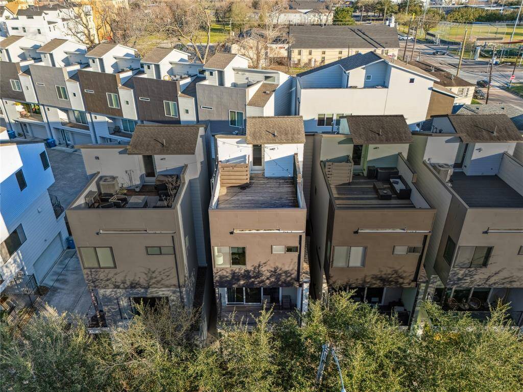 From above, this modern threee-story townhome  with a rooftop terrace stands out with its contemporary architecture, clean lines, and sleek urban design