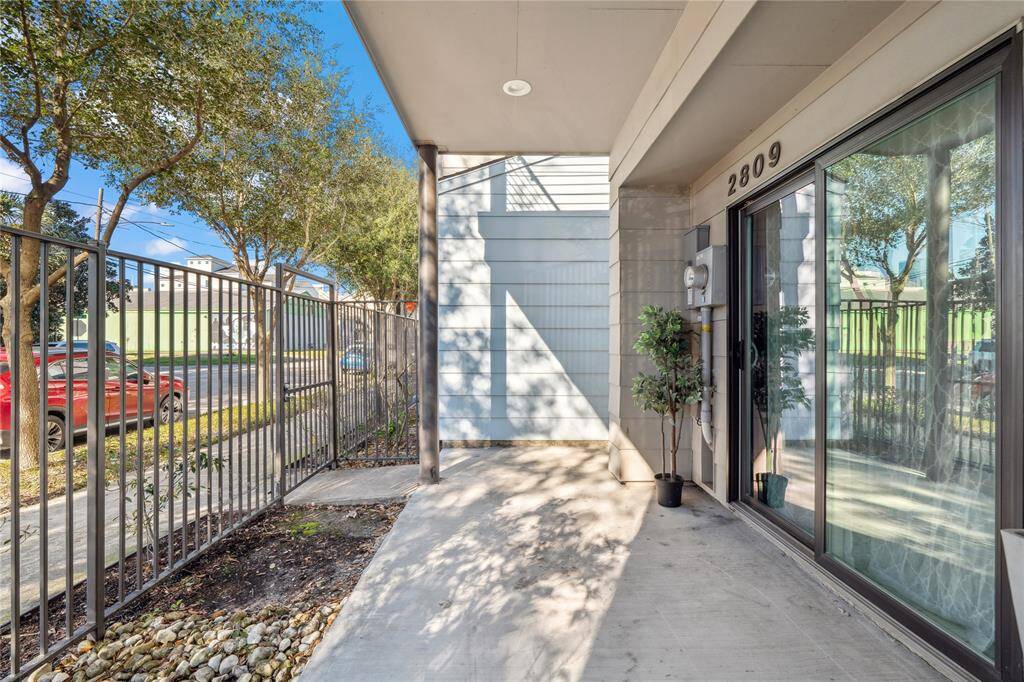 Large windows provide a view of the balcony and surrounding greenery, creating a cozy yet stylish atmosphere.