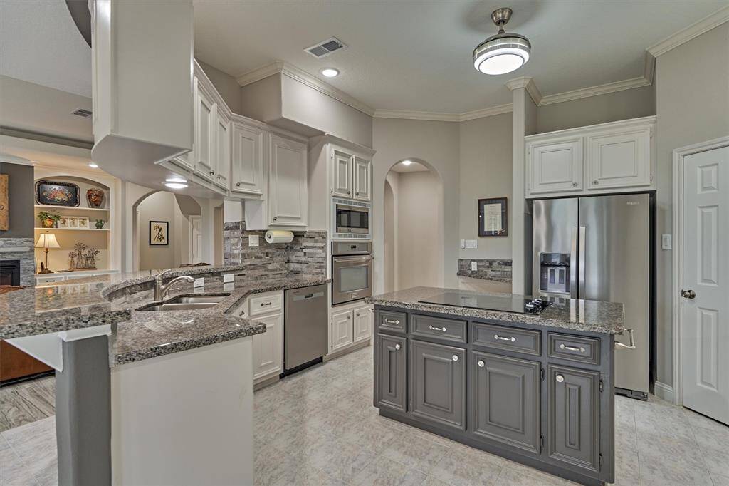 The spacious kitchen overlooks the family room and breakfast area, making it perfect for entertaining and everyday living. A distinctive curved breakfast bar offers additional seating and echoes the elegant curved architecture found throughout the home.