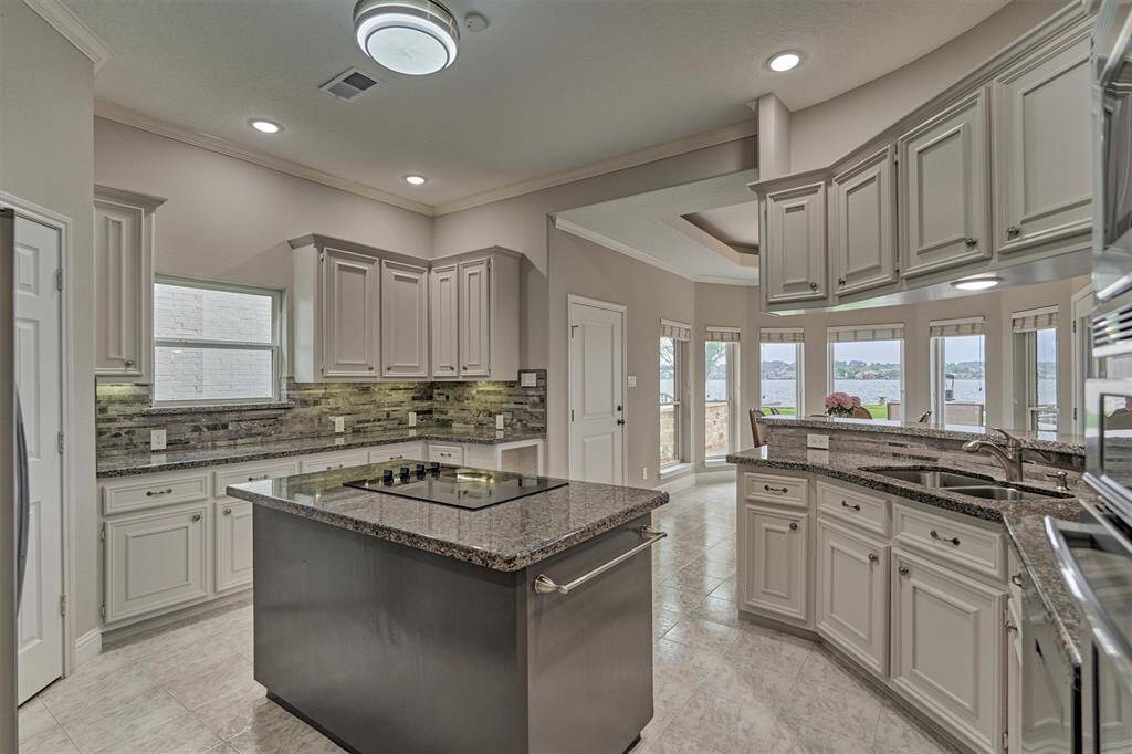 This kitchen offers abundant cabinet storage, ample counter space for food preparation and a walk-in pantry, all while providing stunning views of the lake.