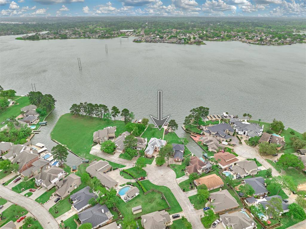 The aerial view highlights this home's prime location on the lake and showcases the stunning views it offers. The large vacant lot to the left is owned by San Jacinto River Authority and is enjoyed by neighbors in close proximity for picnics, fishing and lounging.