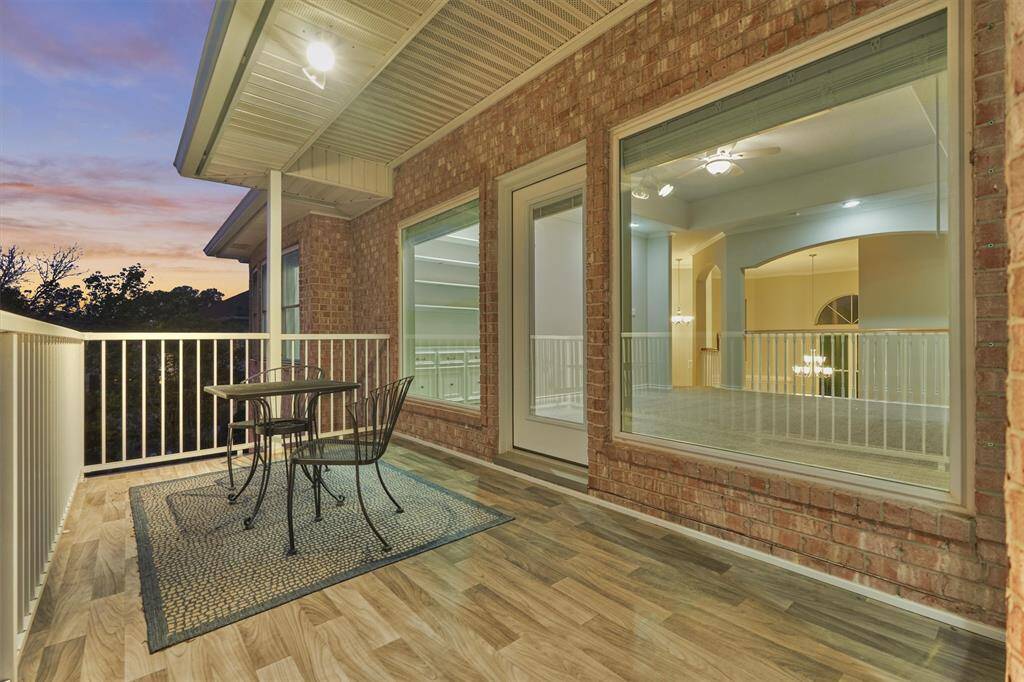 The balcony offers a covered porch spacious enough to accommodate two comfortable seating areas with vinyl plank flooring.