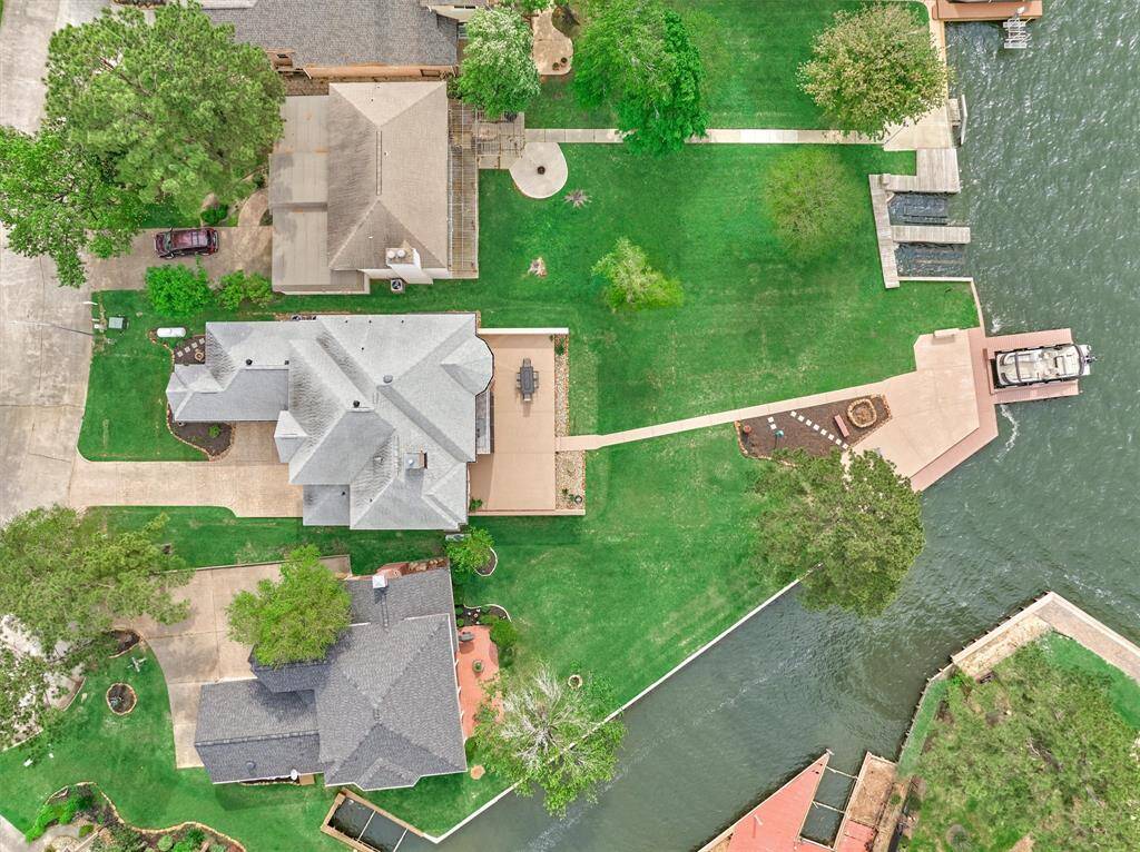 The bird's-eye view reveals the expansive backyard and generous waterfront decking, offering ample space for outdoor games and pets to roam.