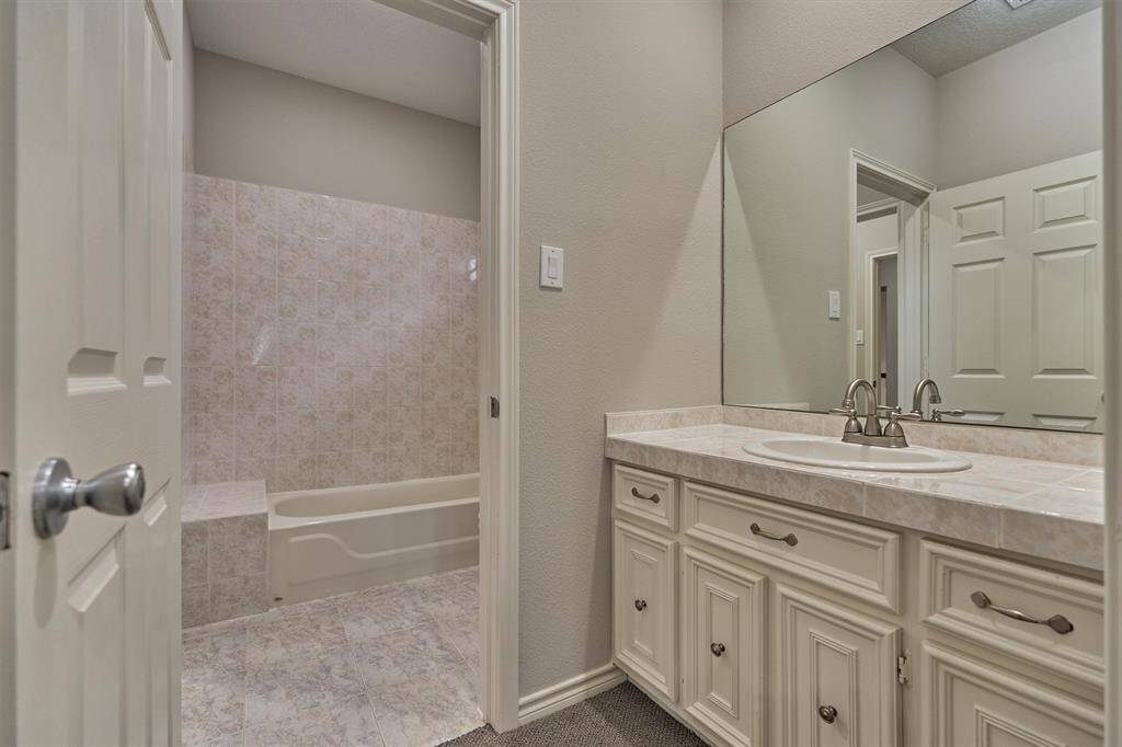 The sink area in this guest bedroom offers ample cabinet and counter space, combining functionality with style for a comfortable and convenient guest experience.