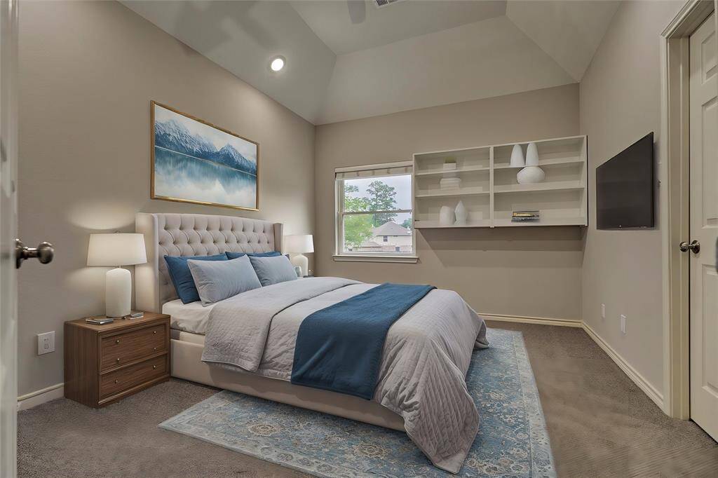 The second guest bedroom features a spacious walk-in closet and built-in shelving for added storage and overlooks the front yard. Virtually staged to show furniture placement.