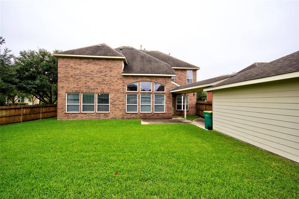 Backyard & Covered Walk between House & Detached Garage. (Old Roof depicted)