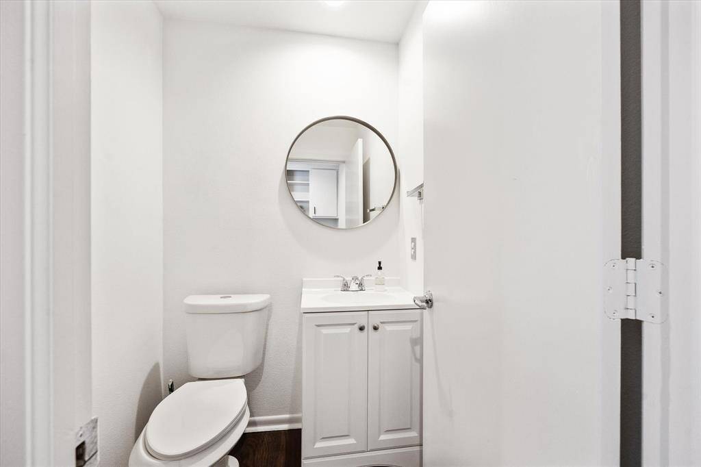 Conveniently located near the family room, the powder bath offers guests a stylish single-sink vanity with a framed mirror above.