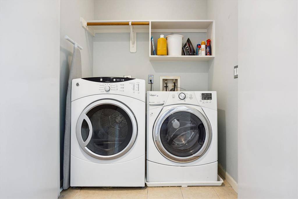 The laundry closet is conveniently located near the bedrooms. It offers built-in shelving for household storage and as an added bonus, the washer and dryer are included in the sale.