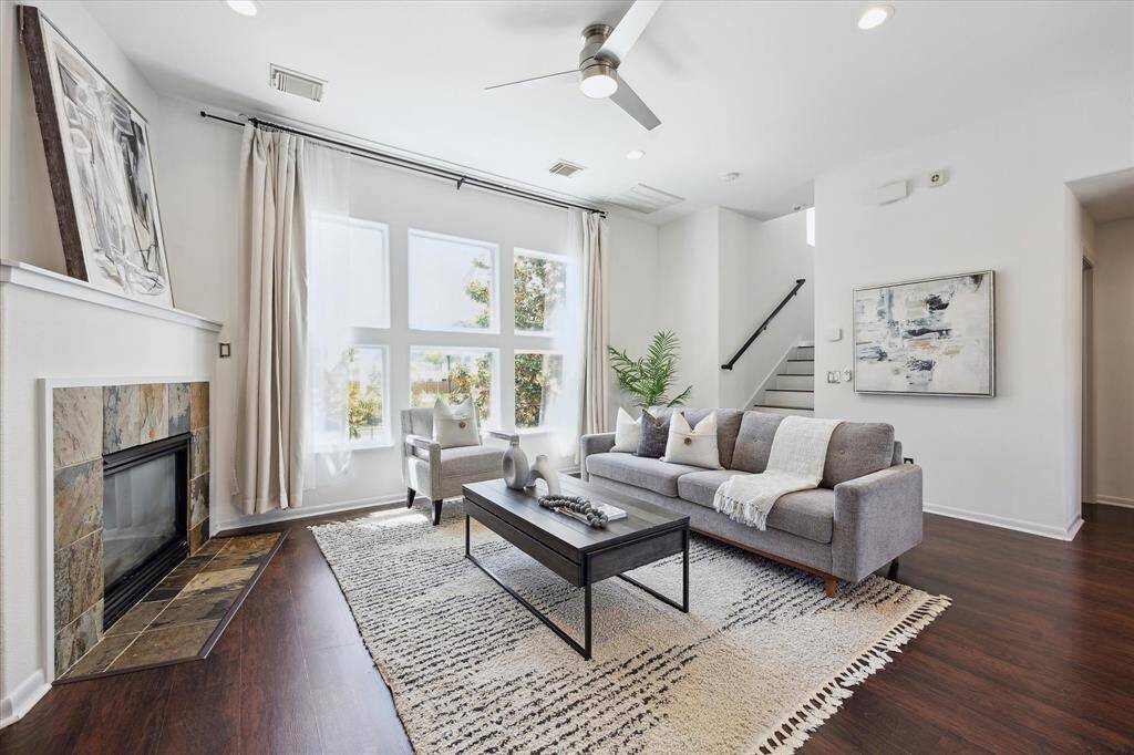 Bathed in natural light from stunning stacked windows, this family room offers a bright and airy retreat for everyday living. Crisp designer paint and rich luxury vinyl plank flooring enhance the open feel, while the romantic gas-log fireplace invites cozy evenings year-round.