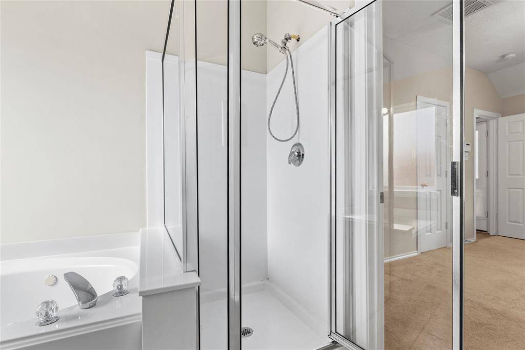 The expansive walk-in shower, adorned with a sleek glass front, offers a luxurious escape for a quick rinse or a refreshing retreat.