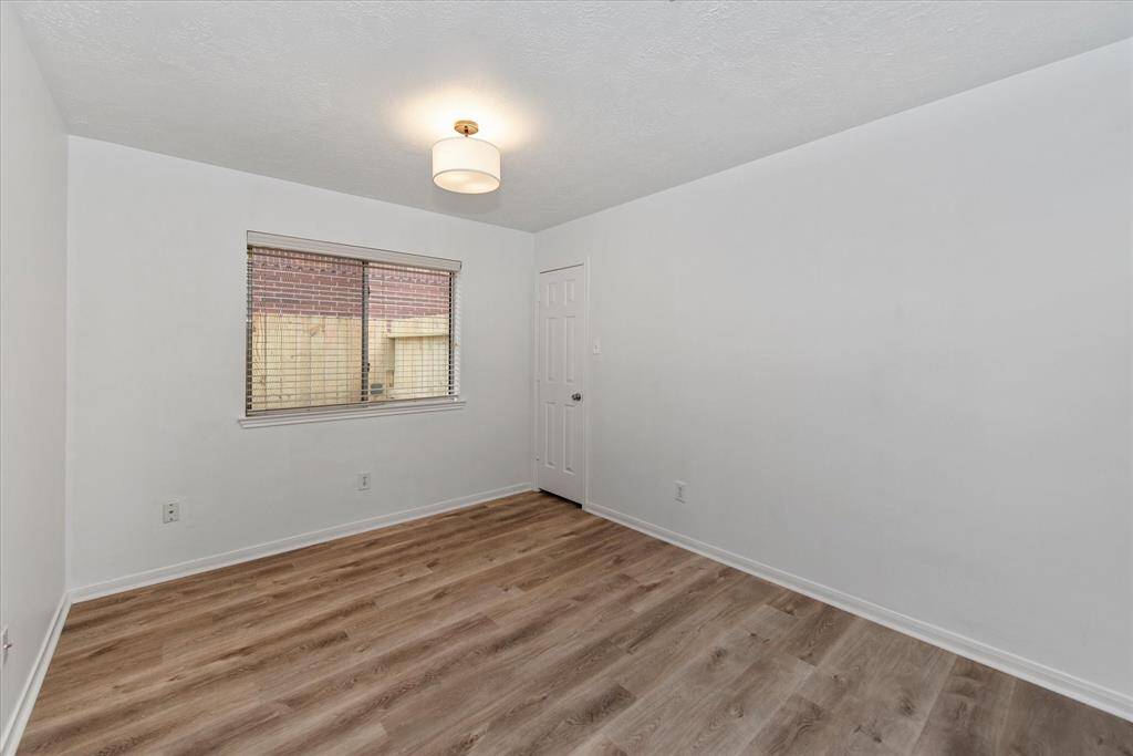 Secondary bedroom with vinyl plank flooring and closet.