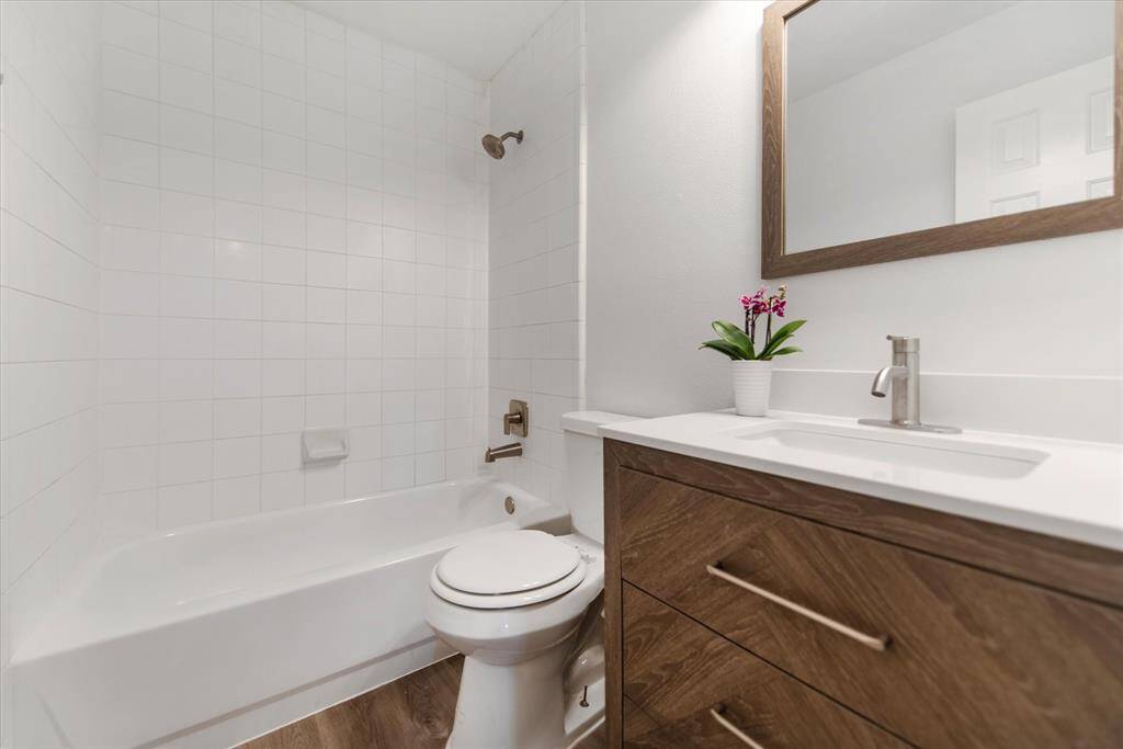 Secondary bathroom with tub and shower combo and beautiful vanity.