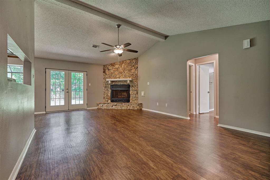 Large family/living area with glass paned double doors to the backyard, keeping the room filled with light