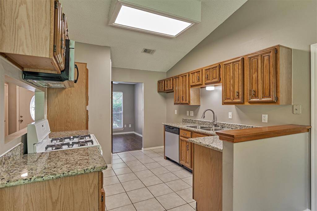 Kitchen with overhead microwave, gas stove, and plenty of cabinet space