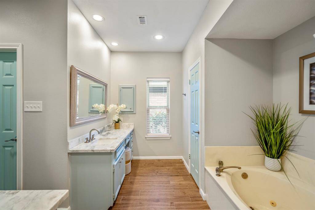 Dual sinks, a large framed mirror, recent hardware and the same cohesive coastal vibe is carried through to the bathroom.